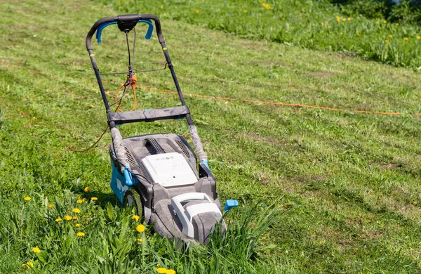 Lawn mower in the spring garden — Stock Photo, Image