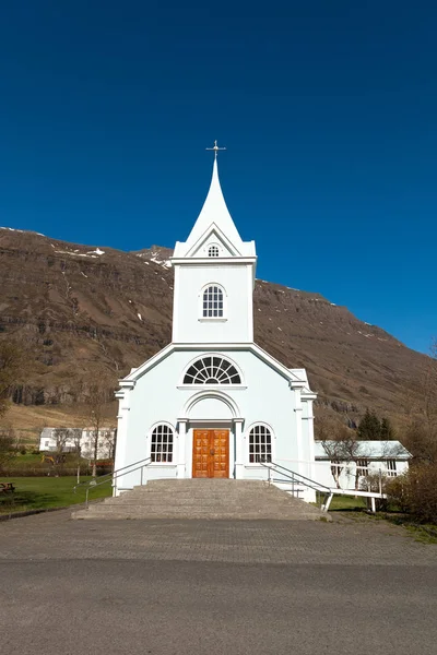Vit kyrka i en liten by i fjordarna på Island — Stockfoto