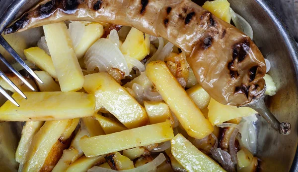 Délicieuses pommes de terre rôties avec oignon et épices dans une casserole sur kitch — Photo