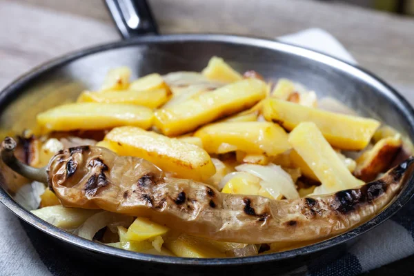 Heerlijke geroosterde aardappelen met ui en specerijen in een pan op Kitch — Stockfoto