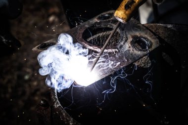 An experienced welder at work. Preparation and welding process o clipart