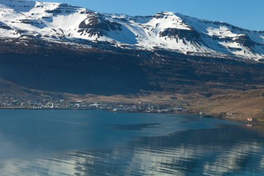 Icela fiyortundaki küçük kasaba ve karlı dağların manzarası