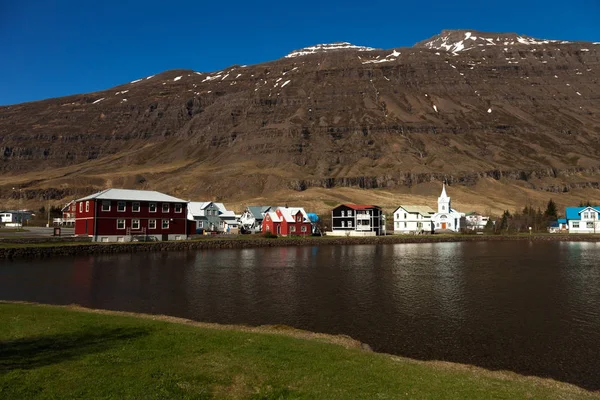 Utsikt till den lilla staden och snöiga bergen i fjorden Icela — Stockfoto