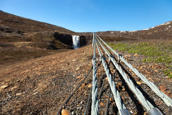 Human and nature: clean water of waterfall and asphalt road on a