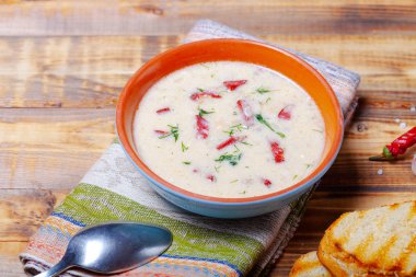 Ekşi krema, ekmek ve yanmış ahşap ta baharat ile baharatlı çorba