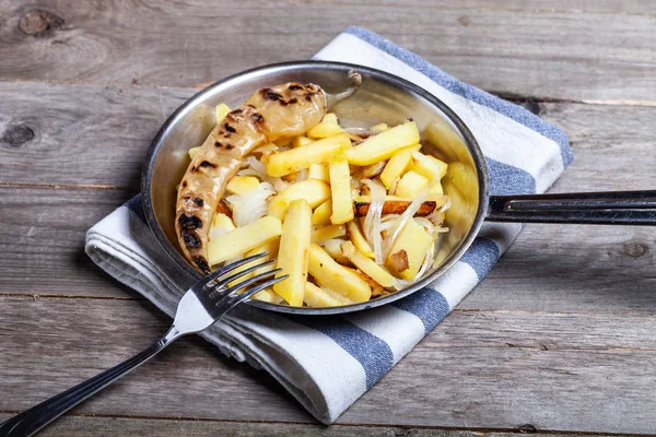 Délicieuses pommes de terre rôties avec oignon et épices dans une casserole sur kitch — Photo