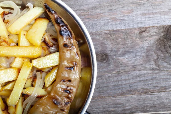 Délicieuses pommes de terre rôties avec oignon et épices dans une casserole sur kitch — Photo