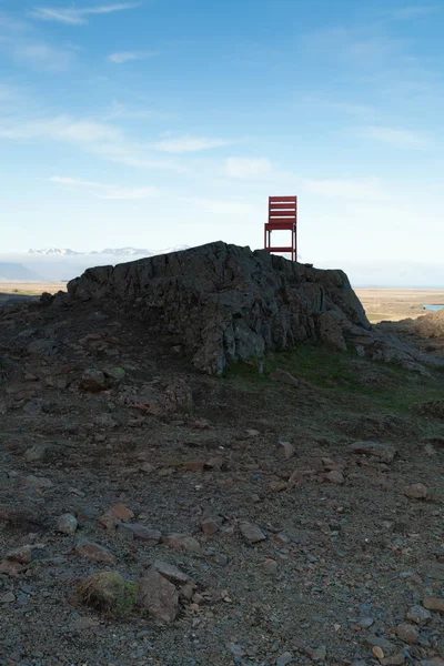 Rode houten stoel op een leeg steenachtig landschap in IJsland — Stockfoto