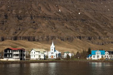 Icela fiyortundaki küçük kasaba ve karlı dağların manzarası