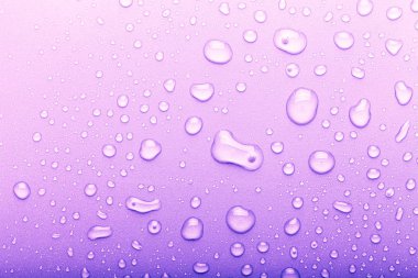 Renkli arka planda su damlaları. Seçici odak. Mor. T