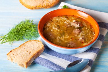 Ahşap bir masada erişte ve köfte ile ev yapımı çorba. Eski