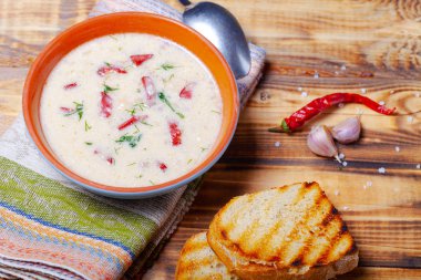 Ekşi krema, ekmek ve yanmış ahşap ta baharat ile baharatlı çorba