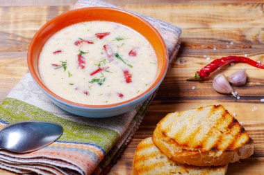 Ekşi krema, ekmek ve yanmış ahşap ta baharat ile baharatlı çorba