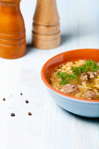 Hausgemachte Suppe mit Nudeln und Frikadellen auf einem Holztisch. trad — Stockfoto