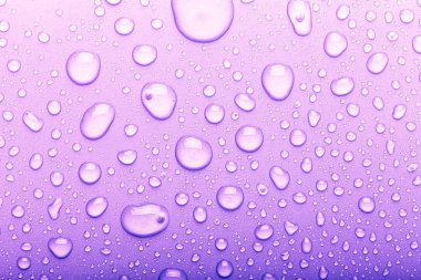 Renkli arka planda su damlaları. Seçici odak. Mor. T