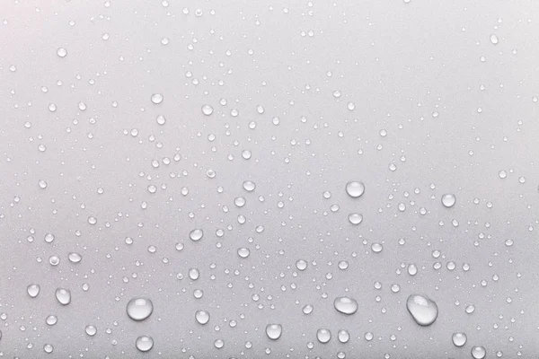 Gotas de água em um fundo a cores. Cinza — Fotografia de Stock