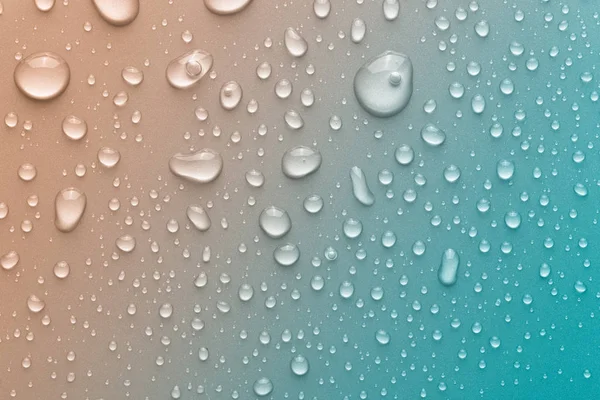 Gotas de água em um fundo a cores — Fotografia de Stock