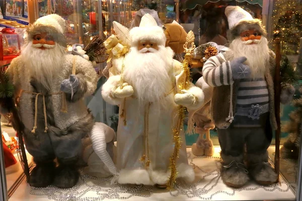 Yeni yıl ve Noel. Üç Noel Baba, hediyeler, dekor ve Noel oyuncak dükkanı penceresinde.