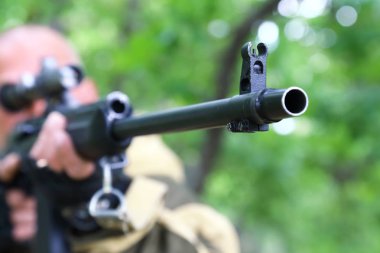 İnsan avcısı silahı hedefliyor. Namlu hedefe nişan.