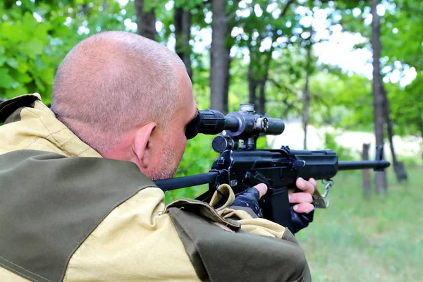 İnsan avcısı ormandaki bir silahtan hedefliyor. Namlu hedefe nişan.