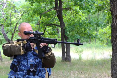Ormandaki kollarıyla insan avcısı. Namlu hedefe nişan.