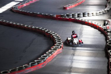 Karting oto yolda sürme. Bir carting direksiyonda genç bir adam.