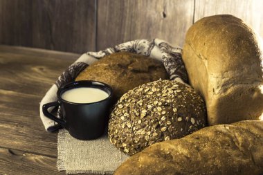 Gıda. Pişmiş ekmek ve süt ahşap masa arka plan üzerinde ürün yelpazesine.