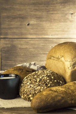 Rustik natürmort. Gıda. Pişmiş ekmek ve süt ahşap masa arka plan üzerinde ürün yelpazesine