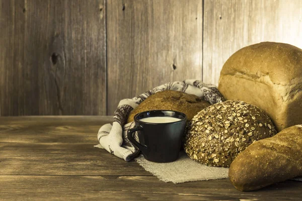 Gıda. Pişmiş ekmek ve süt ahşap masa arka plan üzerinde ürün yelpazesine.