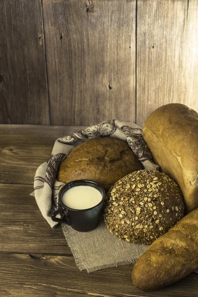 Gıda. Pişmiş ekmek ve süt ahşap masa arka plan üzerinde ürün yelpazesine.
