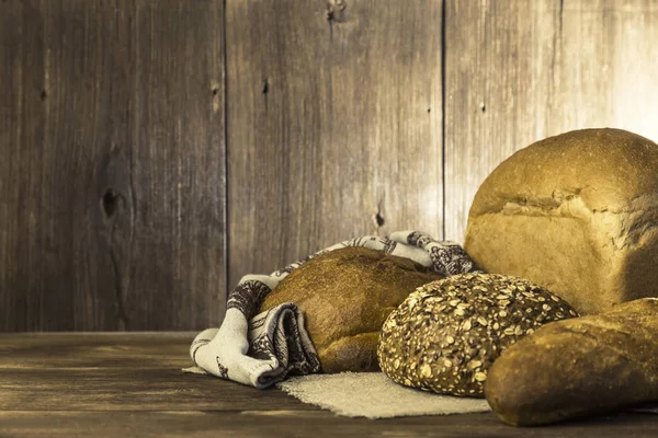 Rustik natürmort. Gıda. Ahşap bir masa arka plan üzerinde ekmek taze pişmiş ekmek çeşitleri