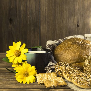Gıda. Rustik natürmort. Taze ekmek ürün yelpazesine bir ekmek, bisküvi ve ahşap masa arka plan üzerinde süt ile bir kupa pişmiş