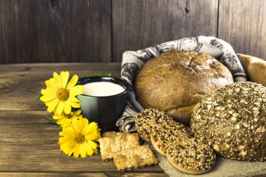 Gıda. Rustik natürmort. Taze ekmek ürün yelpazesine bir ekmek, bisküvi ve ahşap masa arka plan üzerinde süt ile bir kupa pişmiş