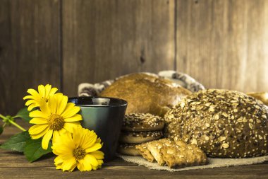 Gıda. Rustik natürmort. Taze ekmek ürün yelpazesine bir ekmek, bisküvi ve ahşap masa arka plan üzerinde süt ile bir kupa pişmiş