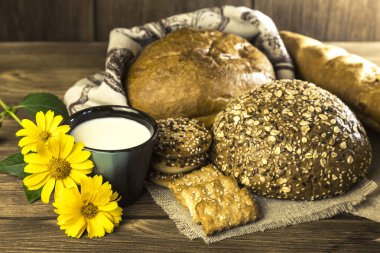 Gıda. Rustik natürmort. Taze pişmiş ekmek ekmek, bisküvi ve kupa ahşap masa dokusuna arka plan üzerine sütlü ürün yelpazesine