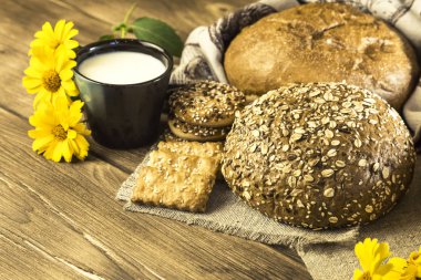 Gıda. Rustik natürmort. Taze pişmiş ekmek ekmek, bisküvi ve kupa ahşap masa dokusuna arka plan üzerine sütlü ürün yelpazesine