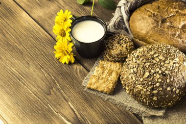 Gıda. Rustik natürmort. Taze pişmiş ekmek ekmek, bisküvi ve kupa ahşap masa dokusuna arka plan üzerine sütlü ürün yelpazesine