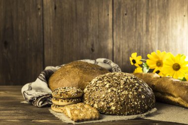 Gıda. Rustik natürmort. Bir fırın ve çerezleri bir ahşap masa doku arka plan üzerinde pişmiş taze ekmek çeşitleri
