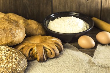 Gıda. Rustik natürmort. Bir fırın, tavuk yumurta ve peynir bir ahşap masa doku bir arka plan üzerinde taze ekmek