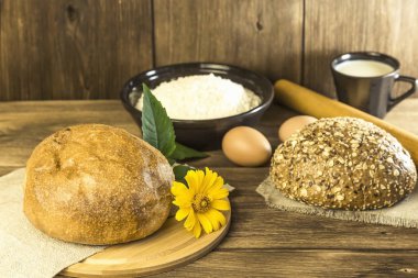 Yemek, kahvaltı. Rustik natürmort. Ekmek, tavuk yumurta, peynir ve süt ahşap bir masa dokusuna arka plan üzerinde taze ekmek