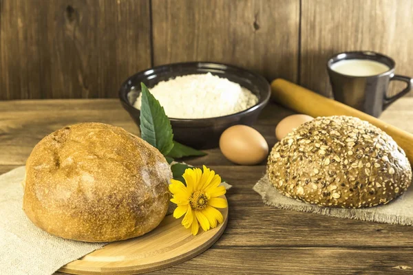 Yemek, kahvaltı. Rustik natürmort. Ekmek, tavuk yumurta, peynir ve süt ahşap bir masa dokusuna arka plan üzerinde taze ekmek