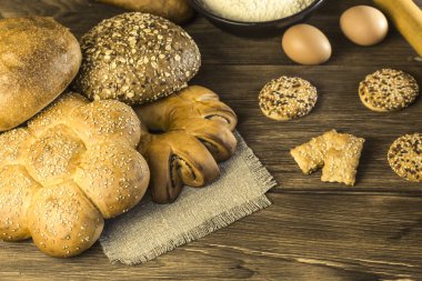 Gıda. Ekmek pişirme. Bir ekmek, bisküvi, tavuk yumurta ve un bir ahşap masa doku arka plan üzerinde taze ekmek