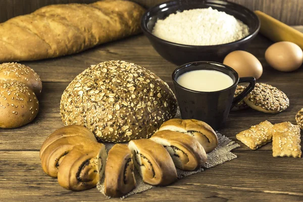 Food. Baking bread. Fresh bread baked in a bakery, biscuits, chicken eggs and cottage cheese on the background of a wooden table texture