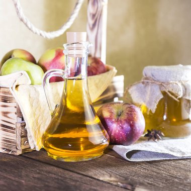 Kırmızı ve yeşil elma tarımsal bir ürün işleme. Evde konserve, sağlıklı diyet vejetaryen yemek. Baharatlı elma elma şarabı sirke, meyve suyu, elma suyu cam sürahi ve olgun meyve kutusunun yanındaki bir kavanoz içinde