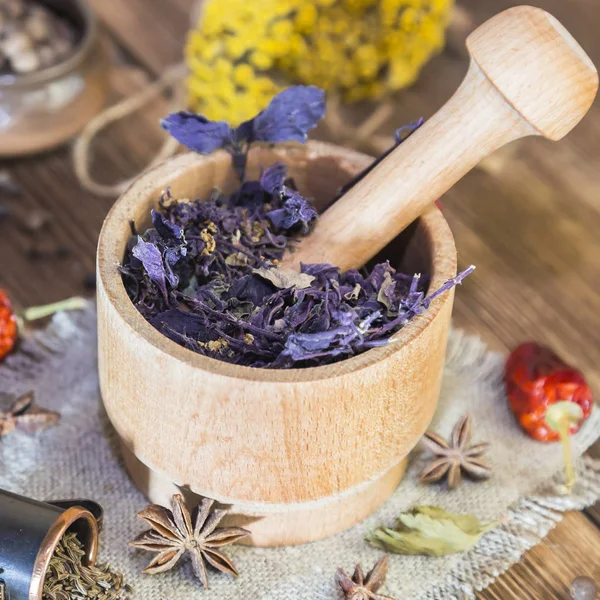 Fragrant torkade helande örter för terapi och kryddig kryddor. På bordet i en mortel är lila basilika, renfana, peppar, chili och kardemumma, i rustik stil. — Stockfoto
