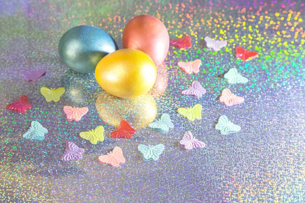 Easter background. Colored eggs of gold, pink, blue turquoise pearl color on a holographic rainbow background with a copy space — Stock Photo, Image