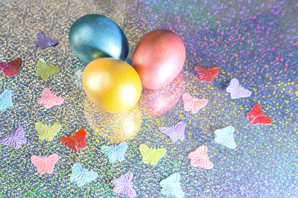 Easter background. Colored pearl eggs of gold, pink, coral, blue and turquoise on a halo background with a copy space — Stock Photo, Image