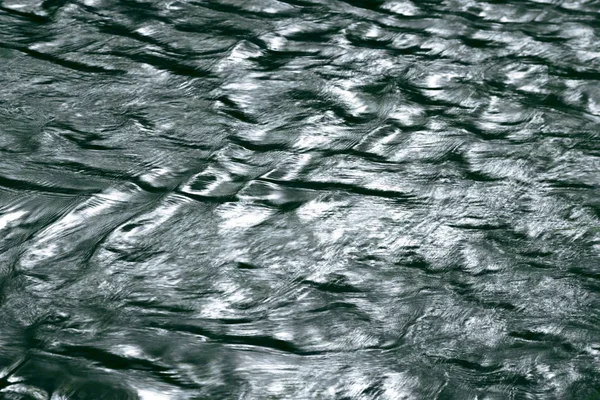 Αφηρημένο φυσικό φόντο με την υφή της επιφάνειας του νερού που ρέει στον ποταμό, υγρό σκούρο μονοχρωματικό χρώμα του μαύρου και του πράσινου με κύματα με χώρο αντιγραφής — Φωτογραφία Αρχείου