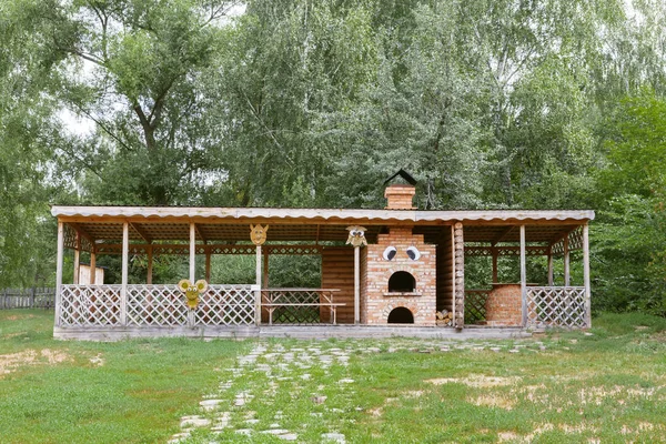 Letní kavárna ve vesnici. Venkovský kanomet na piknik v lese a cihlový sporák na vaření v ohni — Stock fotografie