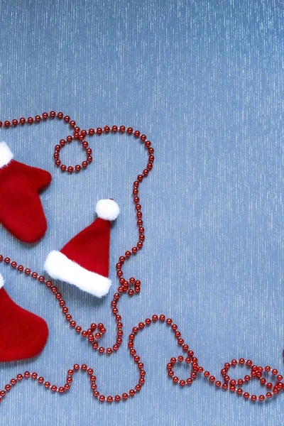Anno nuovo, sfondo di Natale posa piatta. Giocattoli di vacanza cuciti, calzino, manopole, cappello e ghirlanda decorativa di rosso su una superficie azzurra con una struttura di un tessuto di copia-spazio — Foto Stock